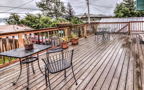 a deck with four chairs and a table with plants at Sea Treasures Inn in Seward