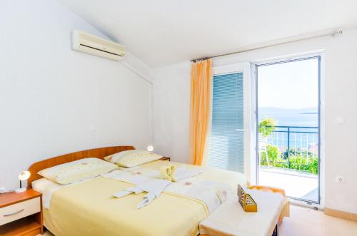 a bedroom with a bed and a large window at Knezovicapartments in Živogošće
