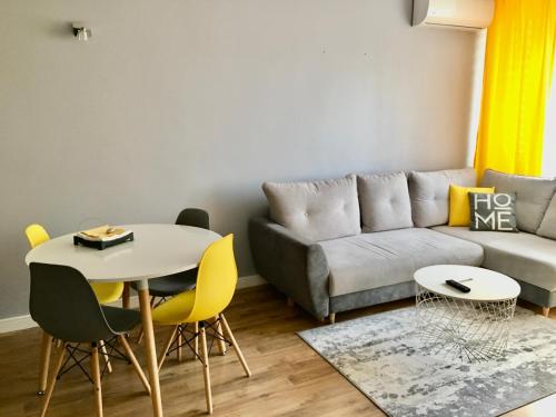 ワルシャワにあるPlac Bankowy Apartmentのリビングルーム(ソファ、テーブル、椅子付)