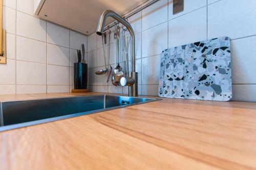 uma cozinha com um lavatório e uma bancada de madeira em Steinfeldstudio in Rottach Egern em Rottach-Egern