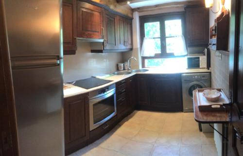 貝納斯克的住宿－Casa el Roso，厨房配有木制橱柜和不锈钢冰箱。