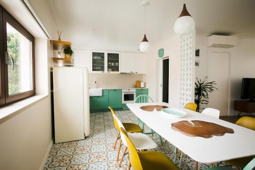 une cuisine avec une table blanche et des chaises jaunes dans l'établissement Eco Villa do Adro, à Porto de Mós