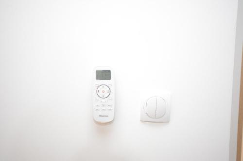a remote control on a wall next to a button at Apartmani CENTAR Vrnjacka Banja & Free Parking in Vrnjačka Banja