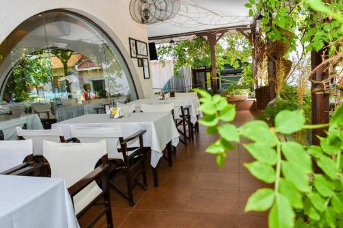 a dining room with white tables and chairs at Visit Sunny Beach Marina Apartments in Ravda