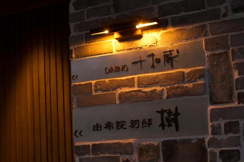 a sign on a brick wall with a light on it at Yufuin Bettei Itsuki in Yufuin