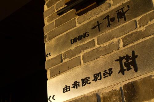 a brick wall with chinese writing on it at Yufuin Bettei Itsuki in Yufuin