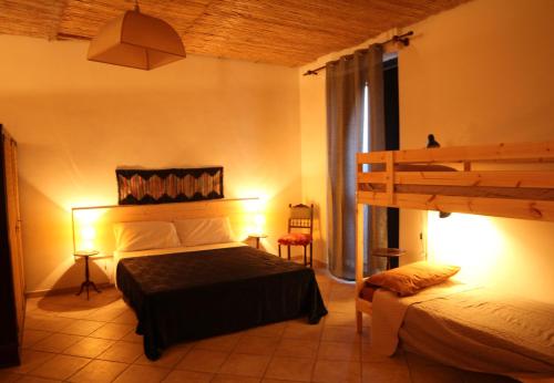 ein Schlafzimmer mit einem Bett und einem Etagenbett in der Unterkunft L'Angoletto in Trecastagni