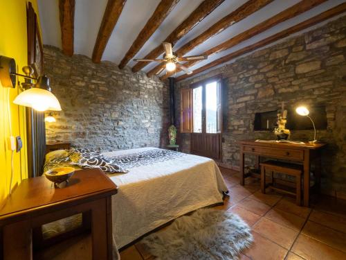 a bedroom with a bed and a stone wall at CASA CRUZ - auto check-in in Boltaña