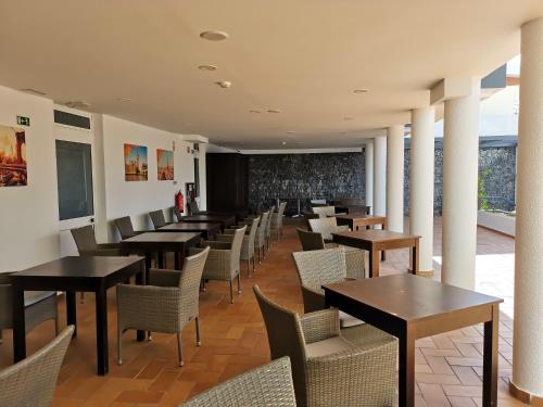 a dining room with tables and chairs and a chalkboard at Santa Cruz Village Hotel in Santa Cruz