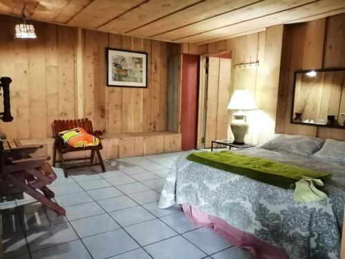 a bedroom with a bed and a table and a chair at Hotel Chalets Los Volcanes in Alajuela City