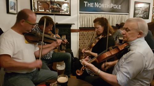 a group of people playing music in a pub at The North Pole in Drumfree