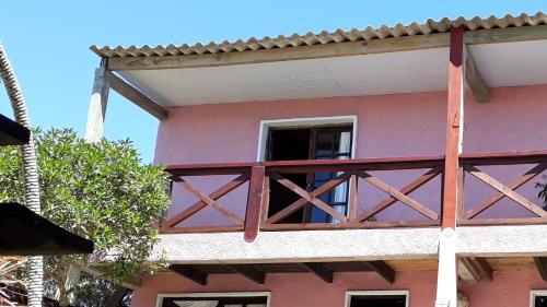 - Balcón de un edificio rosa con ventana en Belarmina posada del mar., en Aguas Dulces