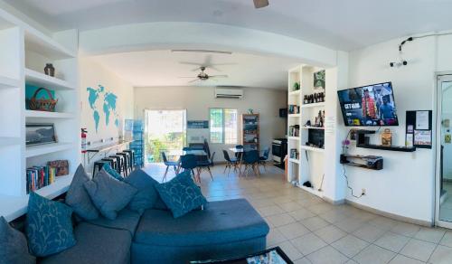 a living room with a blue couch and a tv at Hostal Bucerias in Bucerías