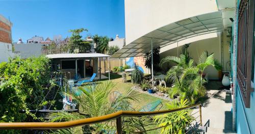 a balcony of a building with a yard with plants at Hostal Bucerias in Bucerías
