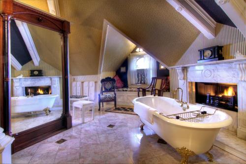 a large bathroom with a tub and a fireplace at Gingerbread Mansion in Ferndale