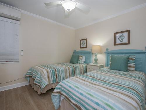 a bedroom with two beds and a ceiling fan at Direct Oceanfront Private Villa Overlooking Pool/Beach - South Forest Beach - Right next to Coligny Plaza in Hilton Head Island