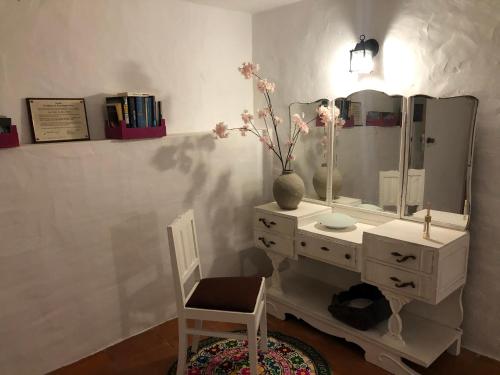 baño con tocador blanco con espejo y silla en The Castle House - Unique Places, en Óbidos
