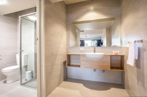 a bathroom with a sink and a toilet at Nightcap at Manhattan Hotel in Ringwood