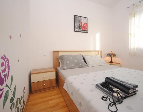 ein Schlafzimmer mit einem Bett mit einem Koffer drauf in der Unterkunft Apartment NOEL in Rogoznica