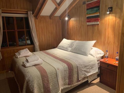 a bedroom with a bed with two towels on it at LA CABAÑA FISHING LODGE in Puerto Ramírez