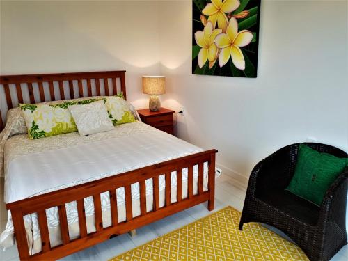 1 dormitorio con 1 cama y 1 silla en Luxury Beachside Home, en Maninoa