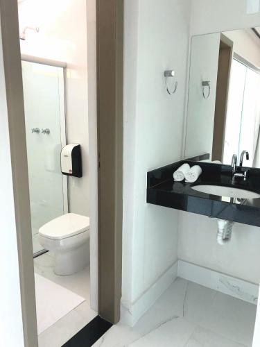 a bathroom with a sink and a toilet at Mirage Hotel in Porto Seguro