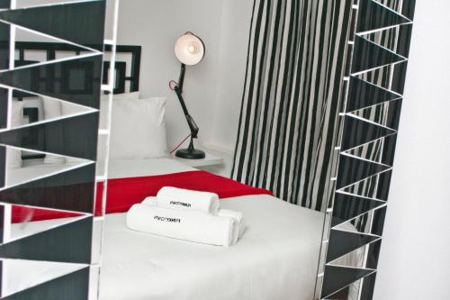 a bedroom with a bed with a red blanket and white towels at Funky Town in Jeffreys Bay