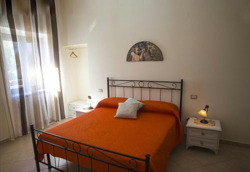 - une chambre avec un lit et une couverture orange dans l'établissement LE PITTURE casa di campagna, à Filiano