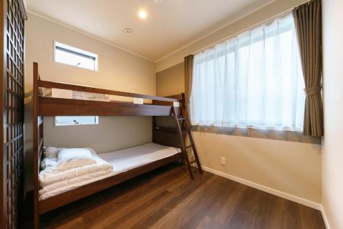 two bunk beds in a room with a window at YADOYA Ueno-Rikyu in Tokyo