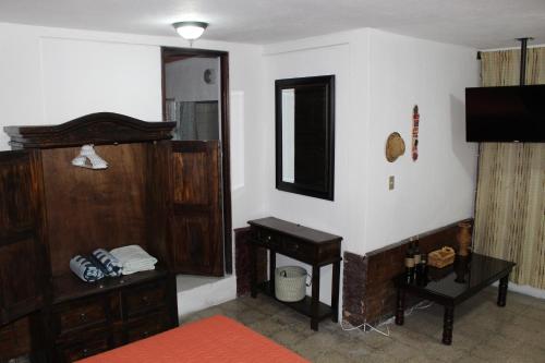 um quarto com um piano e um espelho na parede em Habitaciones Eco-Terrazas em Guatemala