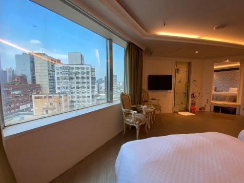 a hotel room with a bed and a large window at 友愛金色商旅Golden Age Hotel in Taipei