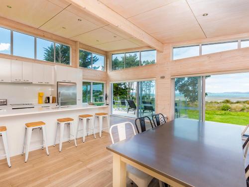 a kitchen and dining room with a large table and chairs at Beachfront Escape - Snells Beach Holiday Home in Snells Beach