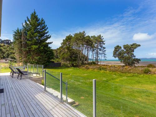 a wooden boardwalk with benches and a view of the ocean at Beachfront Escape - Snells Beach Holiday Home in Snells Beach