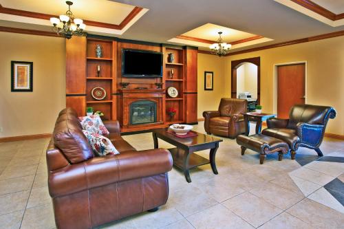 a living room with leather furniture and a flat screen tv at Holiday Inn Express Hotel & Suites Anderson by IHG in Anderson