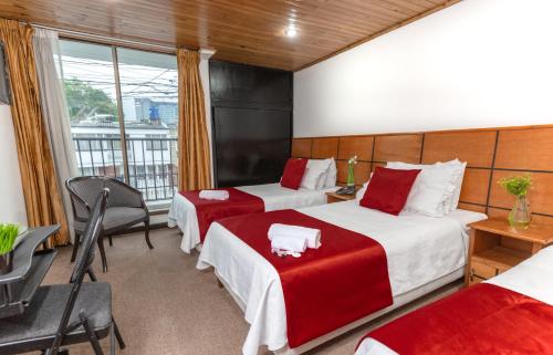 a hotel room with two beds and a balcony at Hotel Casa Quinta Embajada in Bogotá