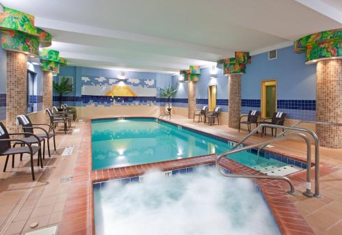 a pool in a hotel lobby with chairs and tables at Holiday Inn Express Hotel & Suites Athens, an IHG Hotel in Athens