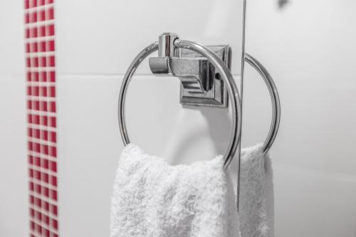 a towel rack with a white shower curtain at Hotel Casa Quinta Embajada in Bogotá