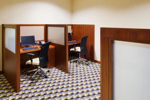 an office with two desks with chairs and a computer at Crowne Plaza Sohar by IHG in Sohar
