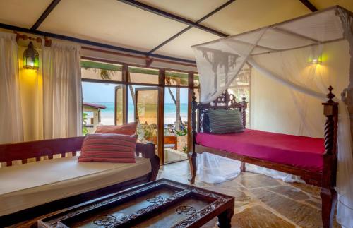 Sala de estar con cama y mesa en Blue Marlin Beach Hotel en Diani Beach