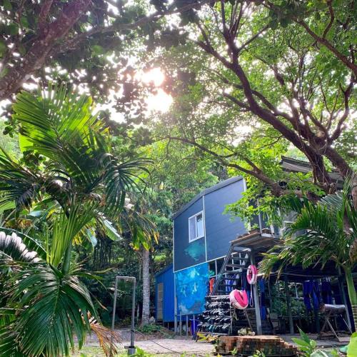a blue building with trees in front of it at Jimmy Explorer Campsite and Dive Center in Lanyu