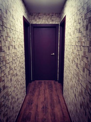 a hallway with a blue door in a brick wall at Perfect Getaway @Vivacity in Kuching