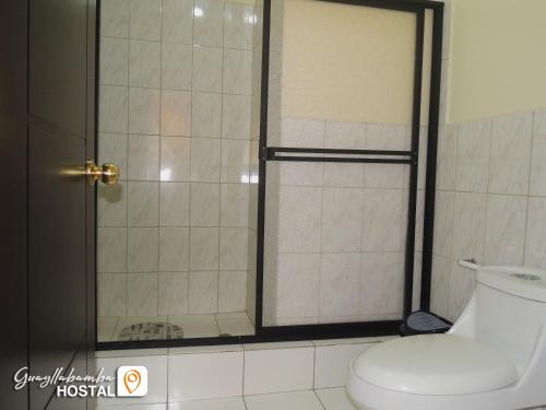 y baño con ducha y aseo. en Hostal Guayllabamba, en Quito