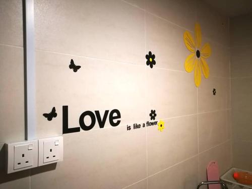 a bathroom with love is like a flower on the wall at Perfect Getaway @Vivacity in Kuching