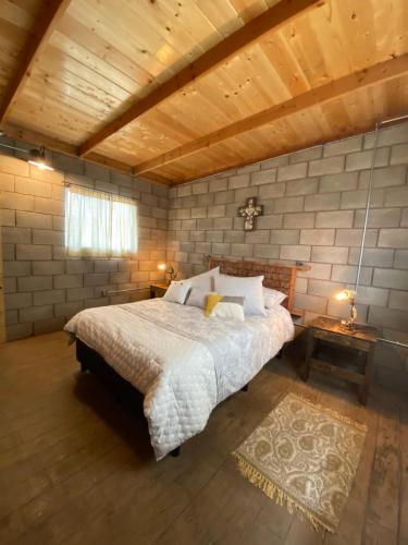 a bedroom with a large bed and a wooden ceiling at Sn Tony Hotel & Spa in Valle de Guadalupe
