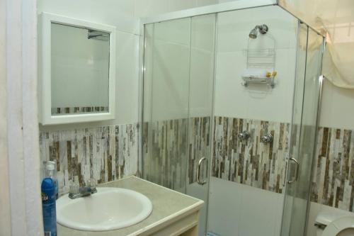 a bathroom with a sink and a glass shower at Aanola Villas A4 Spacious Caribbean Casa in Charlotte