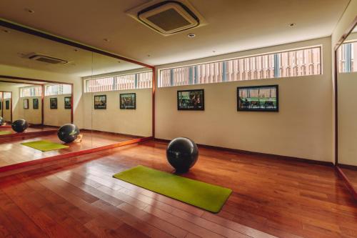 a yoga room with green mats on a wooden floor at SILA Urban Living in Ho Chi Minh City