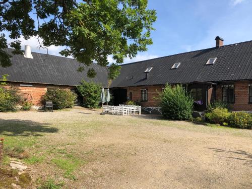 a large brick building with a black roof at Rörums Gårdshotell in Simrishamn