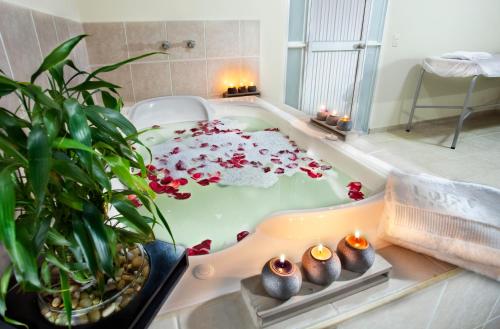 La salle de bains est pourvue d'une baignoire remplie de fleurs. dans l'établissement Loft Hotel Ipiales, à Ipiales