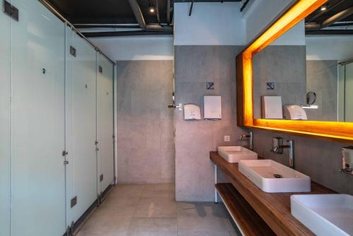 a bathroom with two sinks and a mirror at M Boutique Hostel Legian in Legian