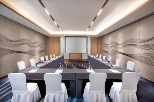 a conference room with a long table and white chairs at Holiday Inn Shunde by IHG in Shunde